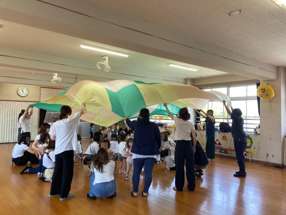 パラバルーンで遊ぶ幼児達の写真