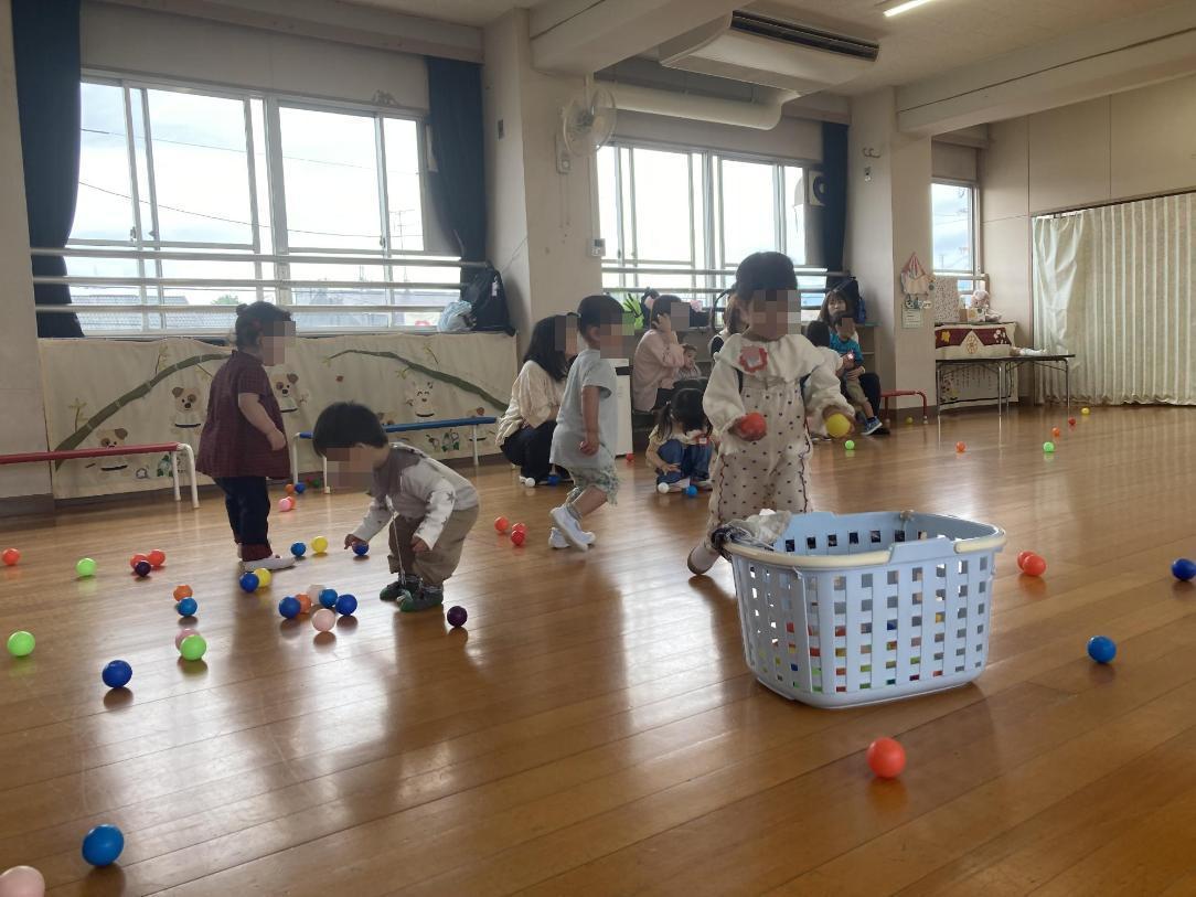 小さいボールで遊ぶ幼児の写真