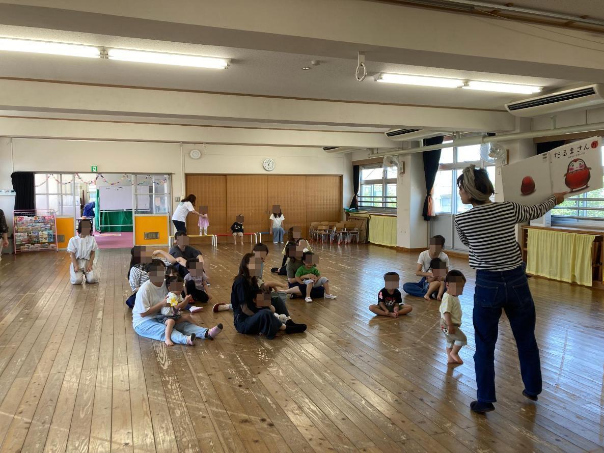 大型絵本の読み聞かせを楽しむ親子の写真