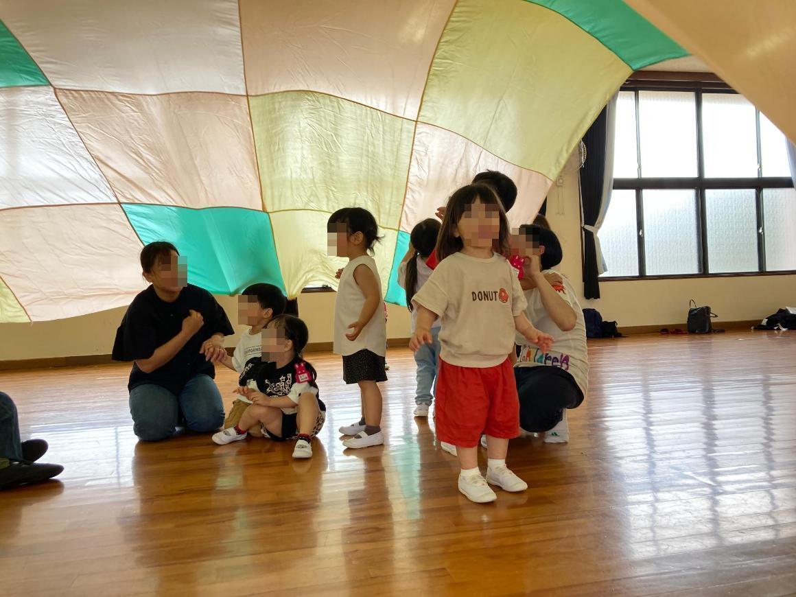 パラバルーンで遊ぶ幼児達の写真