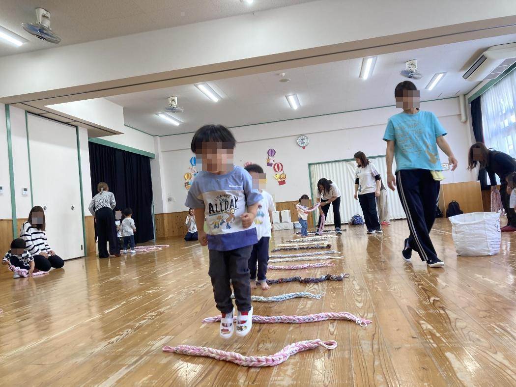 並べた紐をジャンプする子どもたちの写真