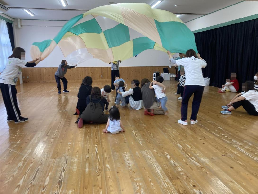 パラバルーンで遊ぶ幼児達の写真