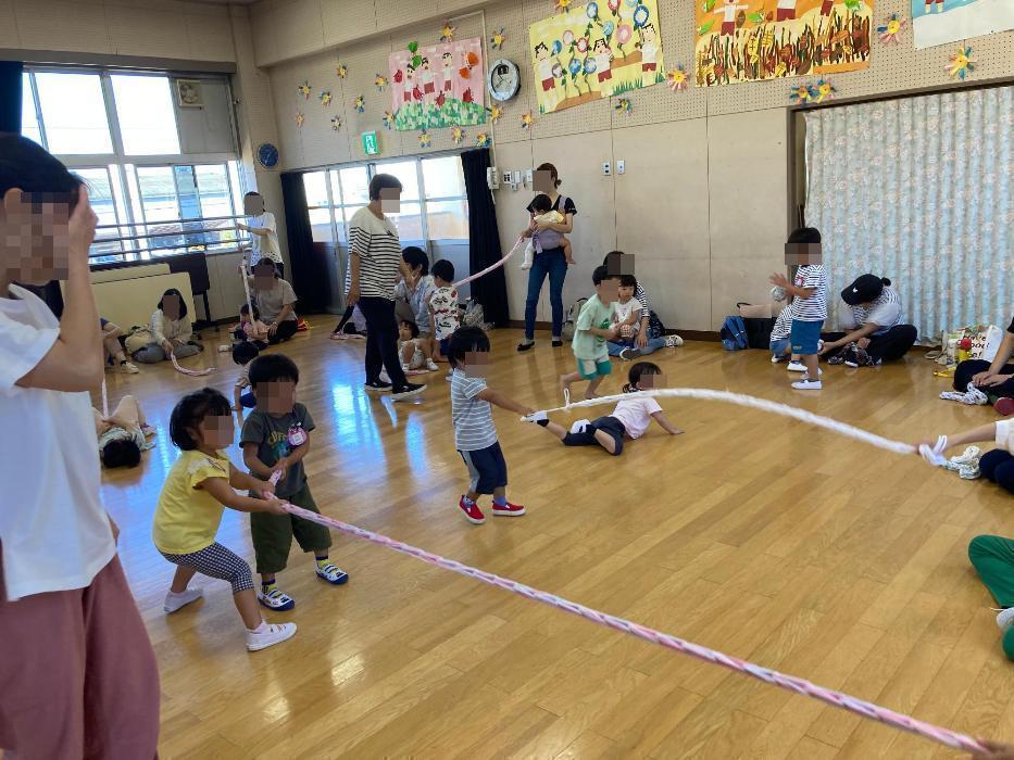 紐をひっぱたり、くづったりして遊ぶ子どもたちの写真