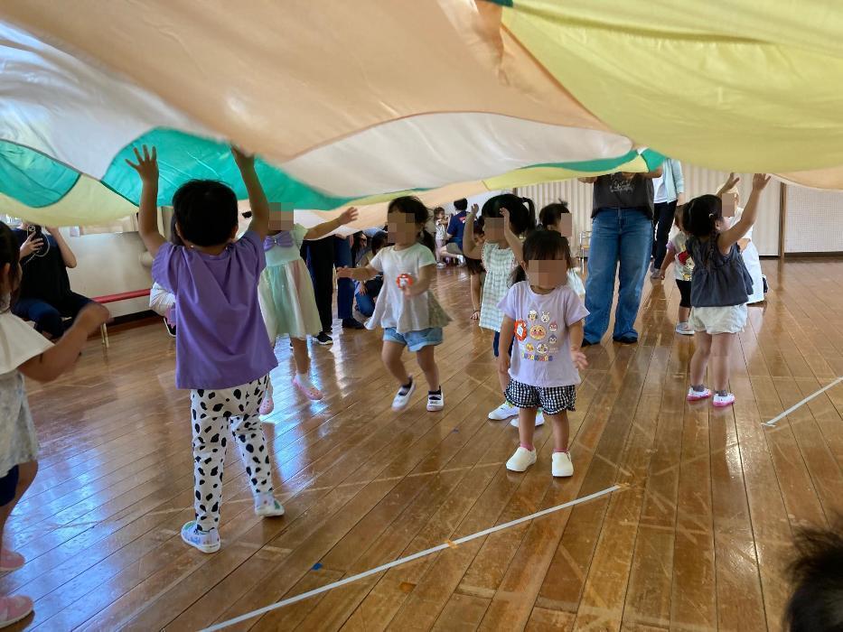 パラバルーンで遊ぶ子どもたちの写真
