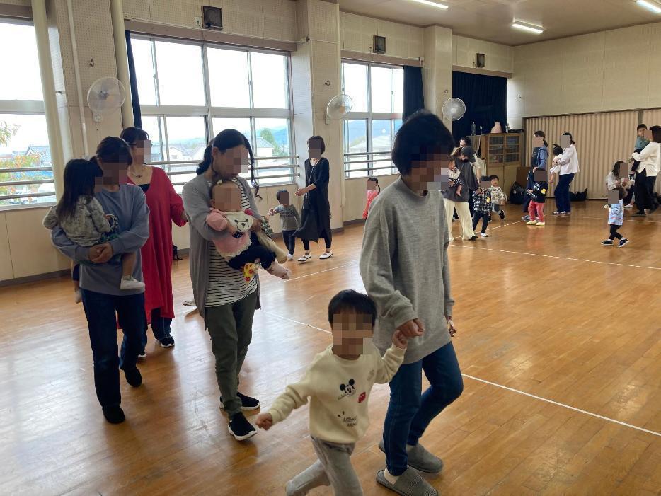 親子で音楽にあわせて歩いている写真
