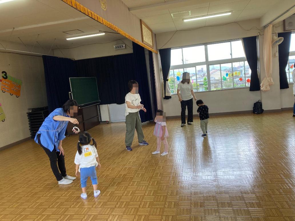 鈴を使ってリズム遊びを楽しむ親子の写真