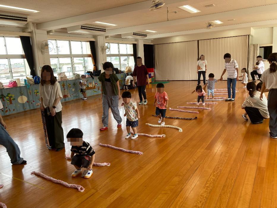 紐を並べてジャンプ遊びを楽しむ子どもたちの写真
