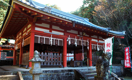 紙垂がいくつも飾られた、灯籠が飾られた神社の写真