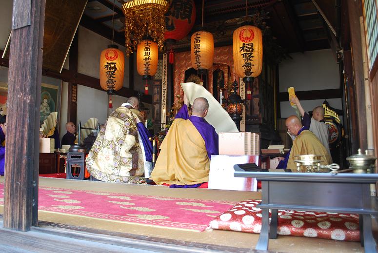 お坊さん数名が寺院の中でお経を読んでいる写真