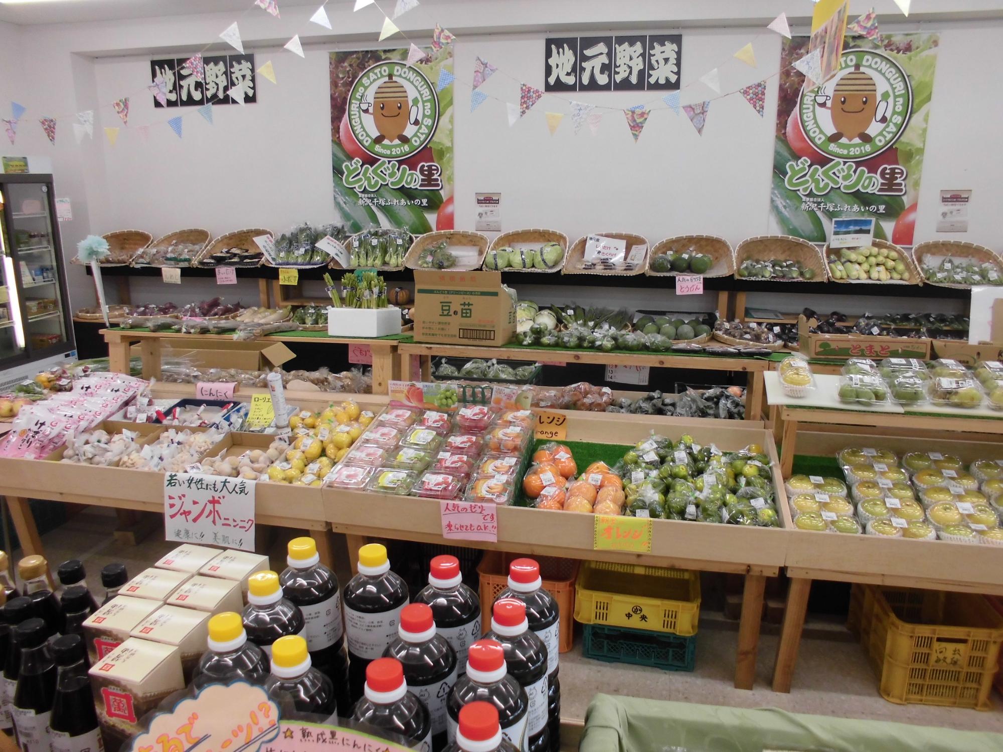 豊富な地元野菜が陳列してある商品棚の写真