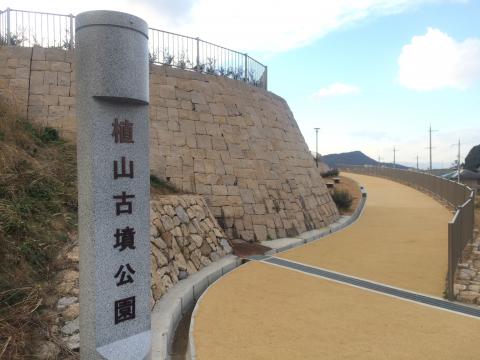 左側に園名柱と石垣がある整備された坂道の写真