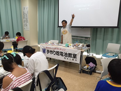 講師が左手を挙げて講座を行っている様子の写真