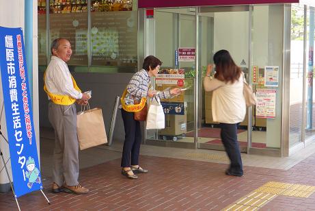 お店の前で街頭啓発活動を実施している男女と通りかかった女性の写真