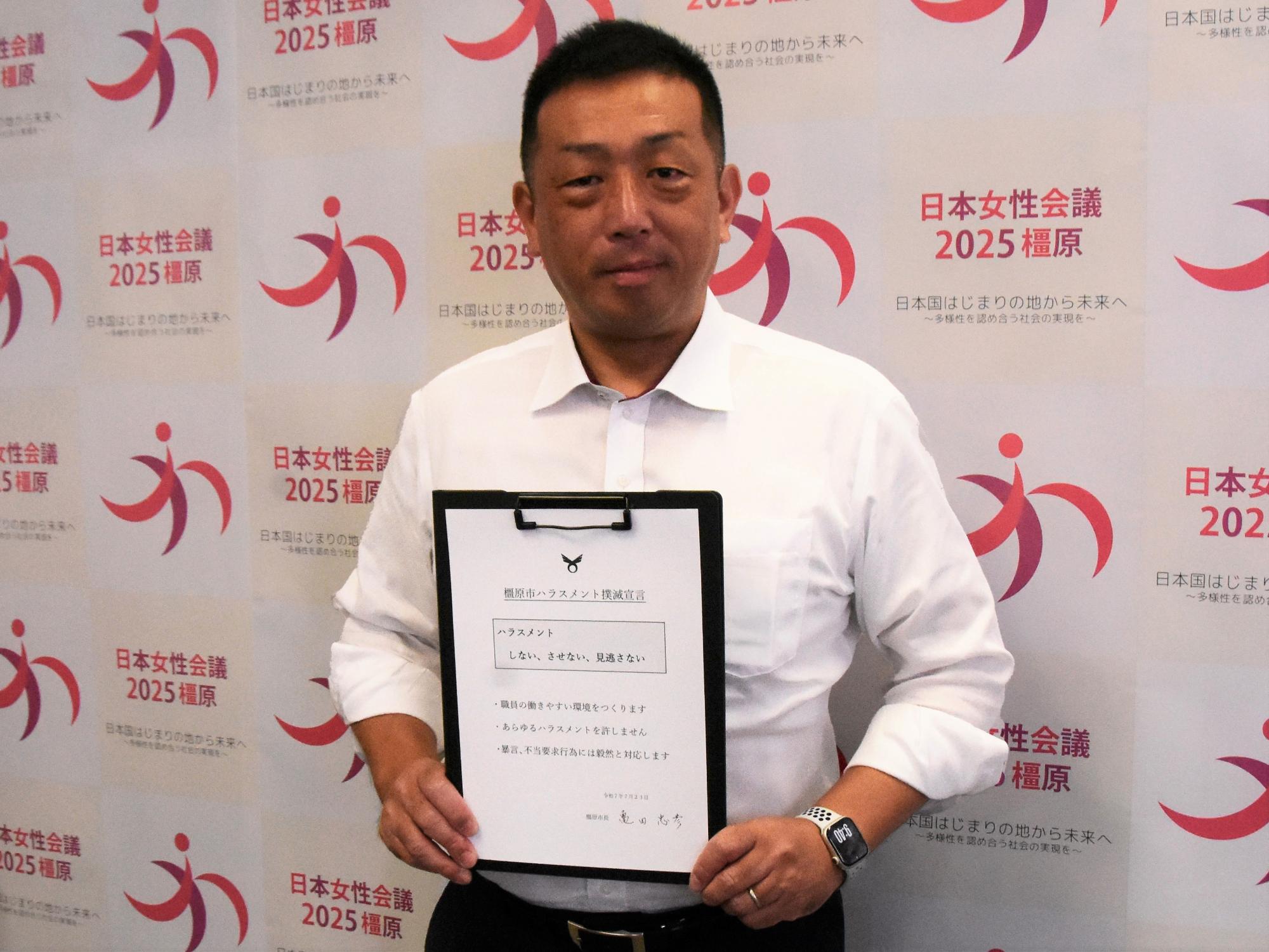 ハラスメント宣言を手にする亀田市長