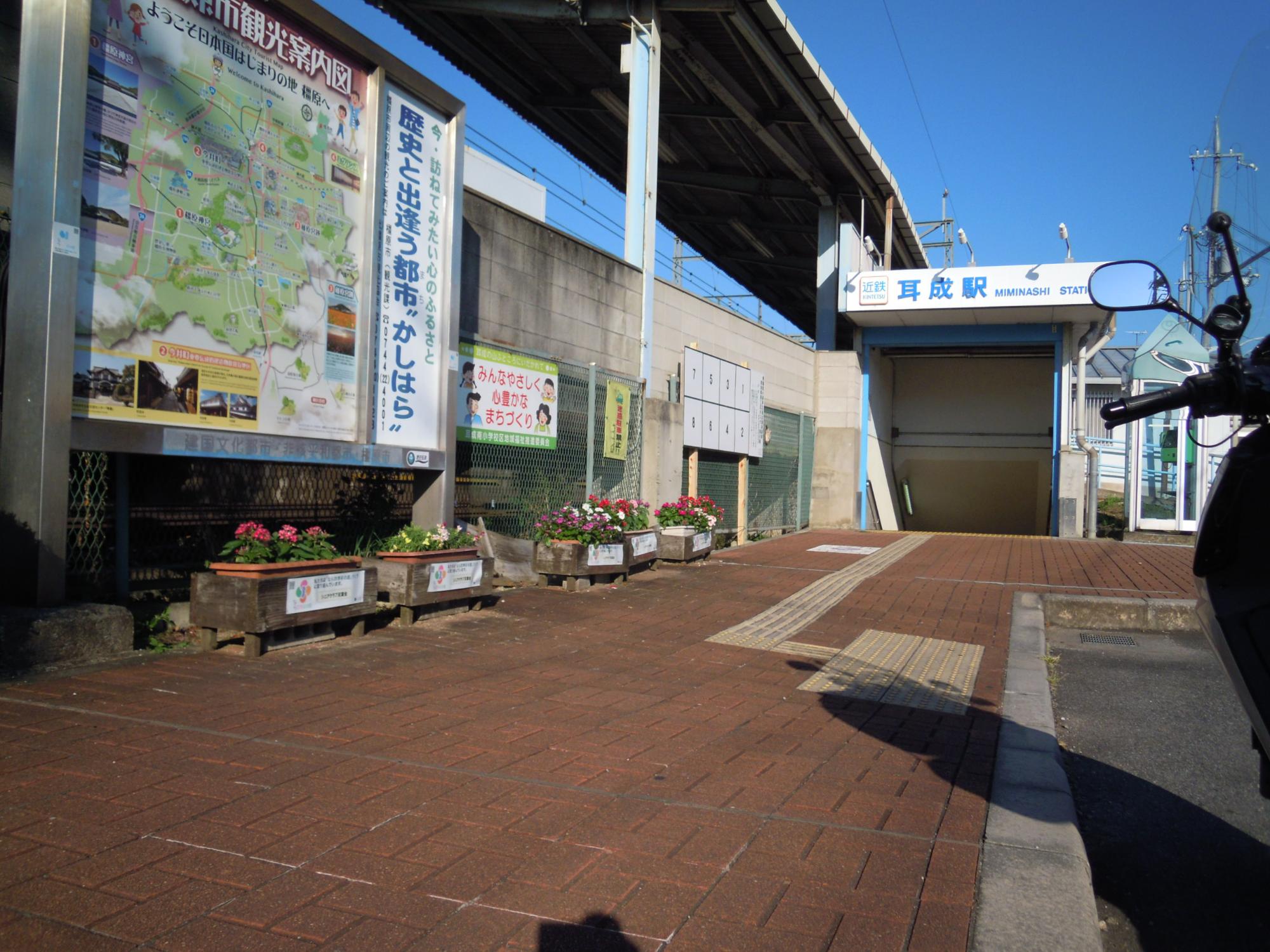 近鉄耳成駅南歩道にある色とりどりの花が咲いている植木鉢5つの写真
