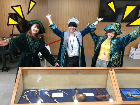 両手を大きく広げた、カザフスタンの衣装を着た三人
