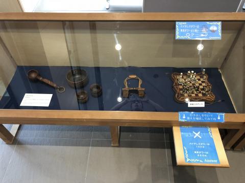 ショーケースに入れられたカザフの器や遊び道具などの写真