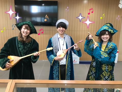 カザフの楽器を持って楽しそうな笑顔の民族衣装を着た3人の写真