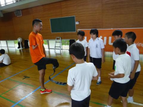 池田選手が立って小学生に説明をしている写真