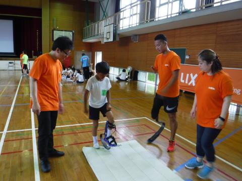 小学生がスポーツ義足の体験をしている写真