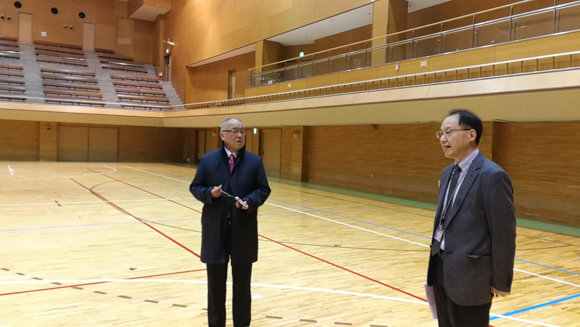 笠井さんがスポーツ施設で男性と話している写真