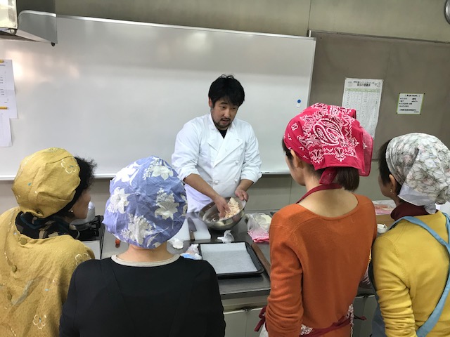 講師がチャクチャクの作り方を実際に調理しながら生徒にレクチャーしている写真