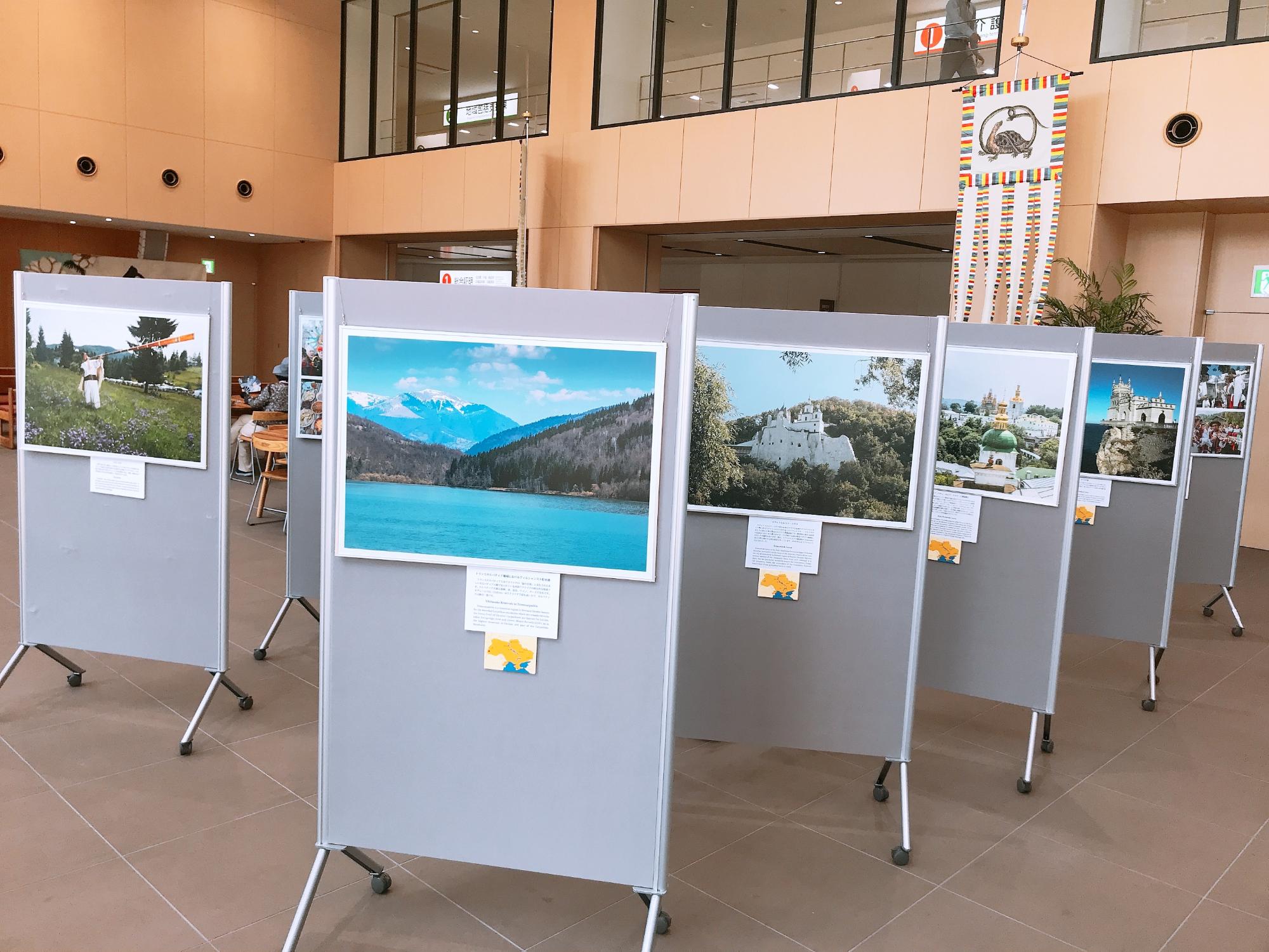 湖の写真や建物の写真など、ウクライナの風景写真がパネルに飾られている様子の写真