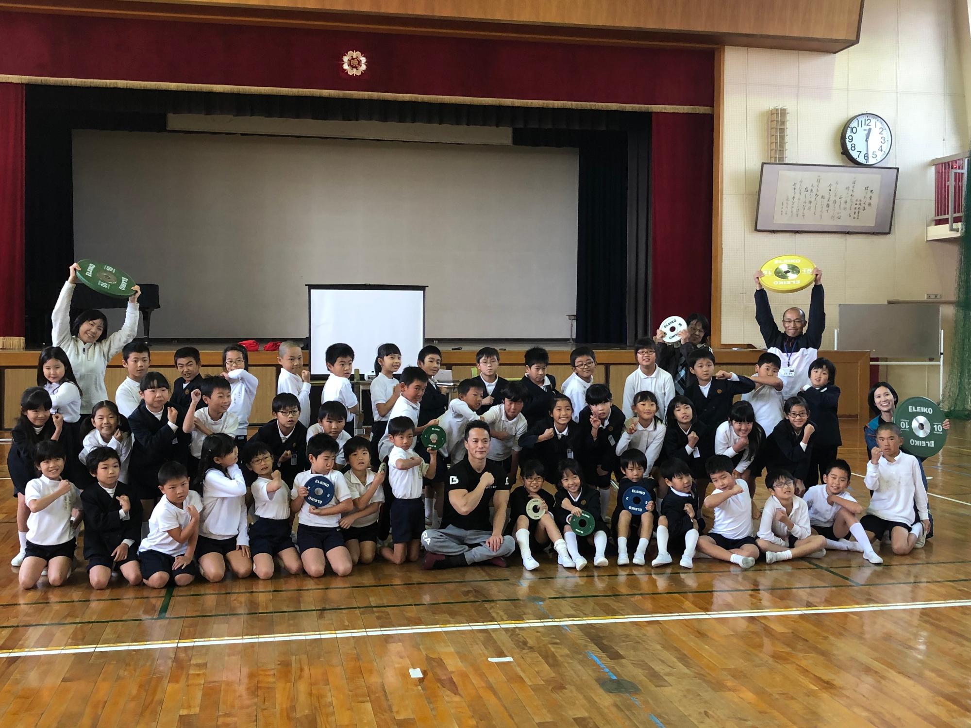 車椅子の選手と児童たちの集合写真