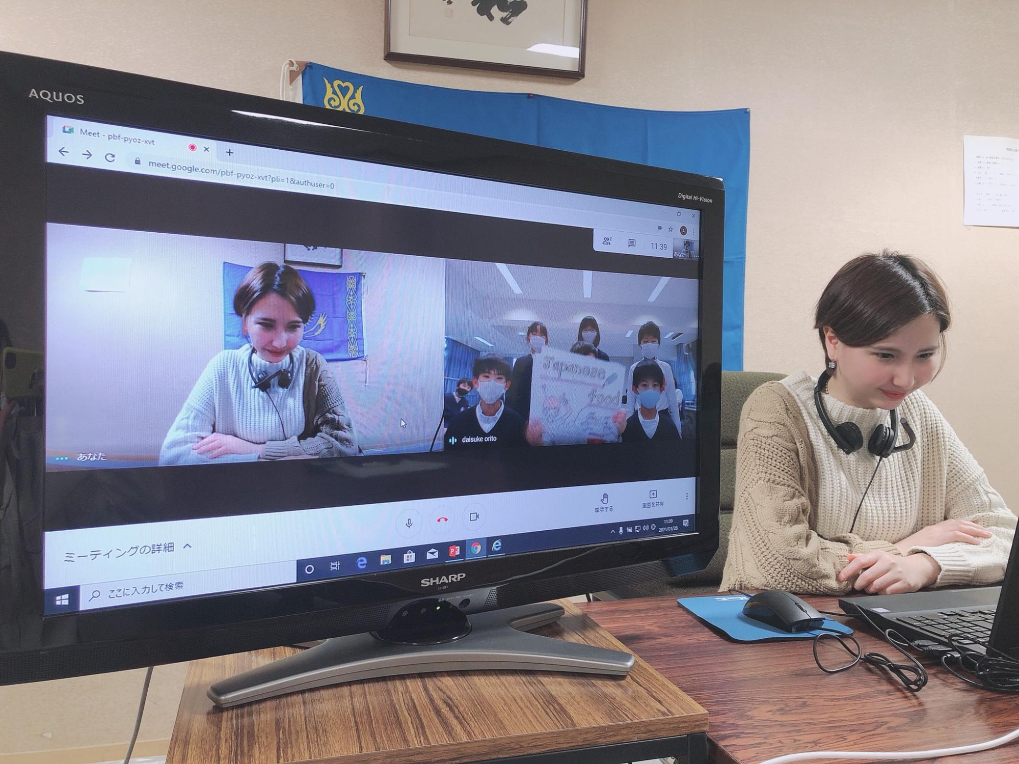 女性がオンライン交流授業の中で画面の中に書いてる子供たちからの質問内容を眺めながら考えている様子の写真
