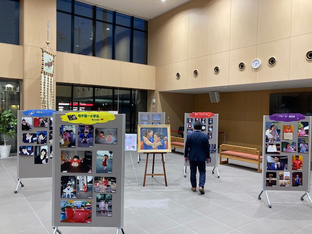 写真が貼られたパネルが並べられた屋内交流スペースの写真