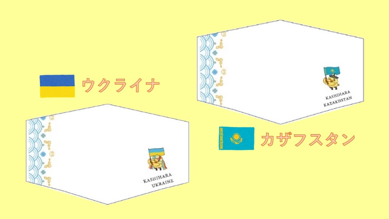 左側に水色と黄色の模様が縦に入っている2枚のマスクのイラスト。ウクライナのデザインは「KASHIHARA UKRAINE」の文字とウクライナの国旗を持った鳥のキャラクターが描かれている。カザフスタンのデザインは「KASHIHARA KAZAKHSTAN」の文字とカザフスタンの国旗を持った鳥のキャラクターが描かれている
