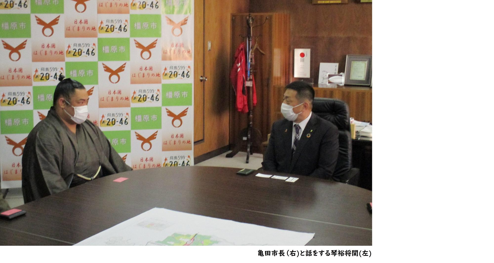 亀田市長(右)と座って話をする琴裕将関(左)の写真