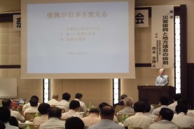 スクリーンに映るスライドを前に研修を受ける議員達の写真