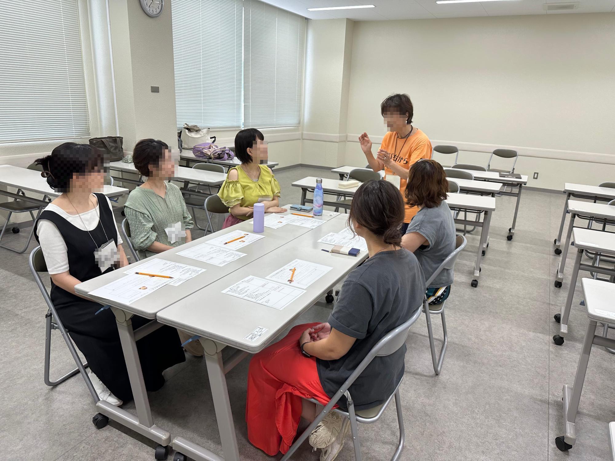 子どもを託児に預けて講座を聞く保護者の写真