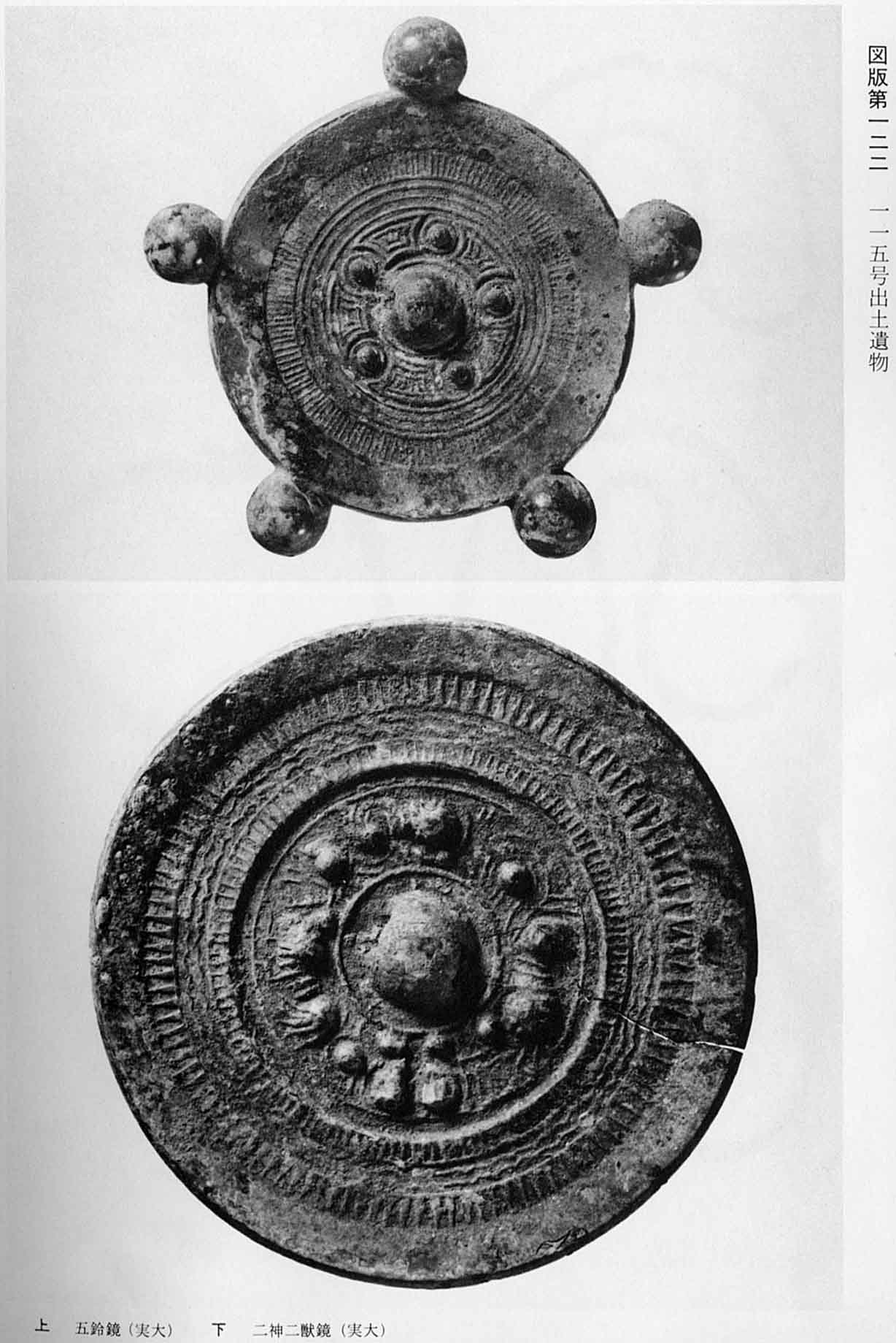 5つの丸い鈴が飾られている鏡と、神や獣がデザインされている鏡が撮影されている、図版122 115号出土遺物のモノクロ写真