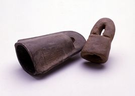 鈴の形と南京錠の形の土製品が横たわって映っている写真