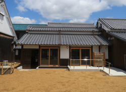 ガラスのサッシのある建物の前にある広い庭の写真