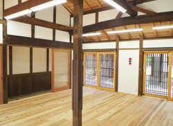 木製のフローリングに白い壁に外が見えるサッシがある建物の内装の写真