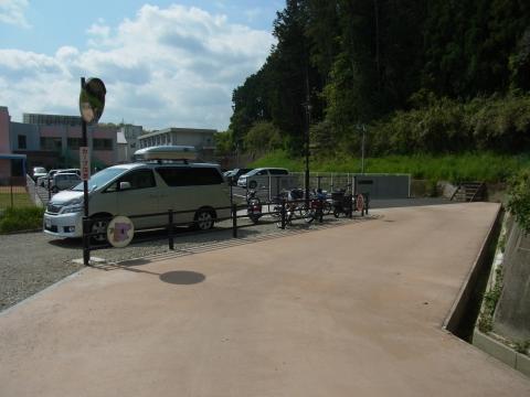 左側にカーブミラーと車が数台止まっている道の写真