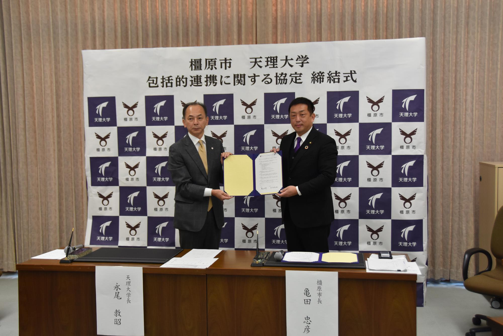 協定締結式の様子(左:天理大学 永尾学長、右:亀田市長)