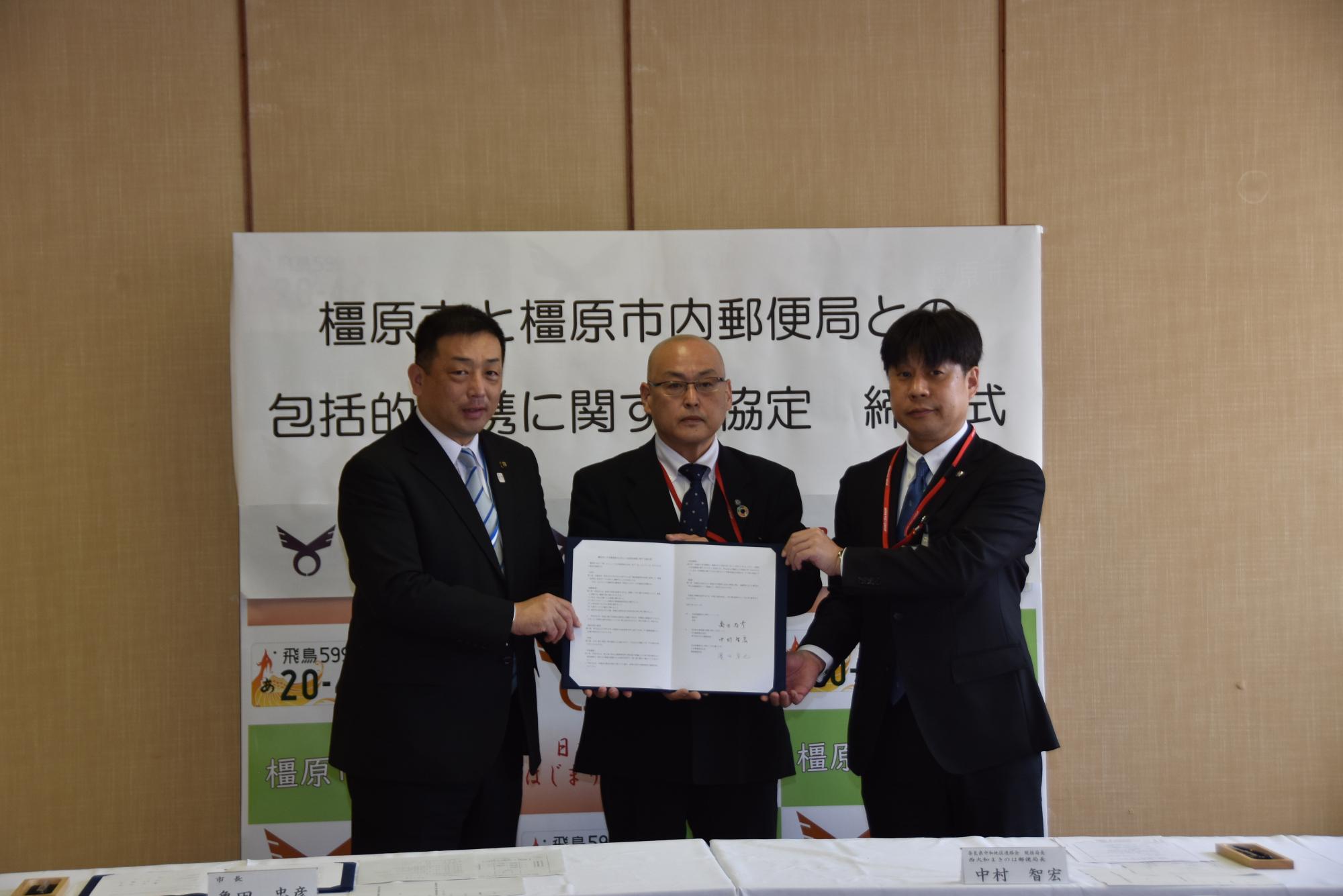 協定締結式の様子(左:亀田市長、中央:日本郵便 県中和地区連絡会 中村統括局長、右:濱田橿原郵便局長)