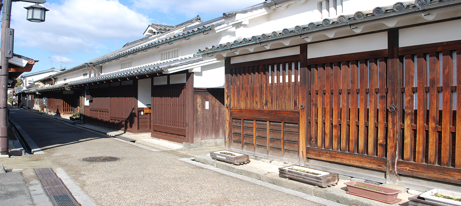 白い壁に灰色の瓦葺屋根の歴史ある家が立ち並ぶ今井町の写真