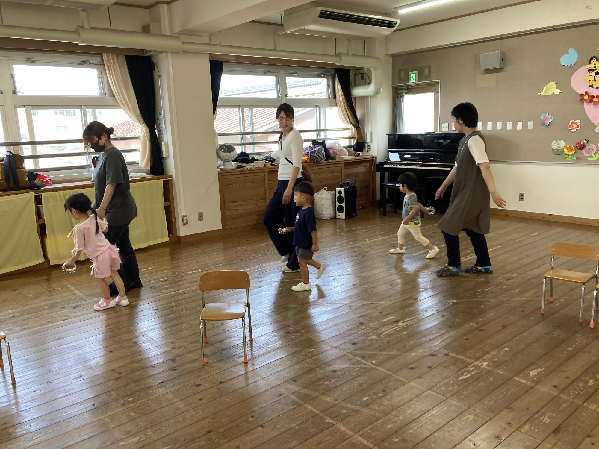 音楽に合わせて楽器を持って歩く子どもたちの写真