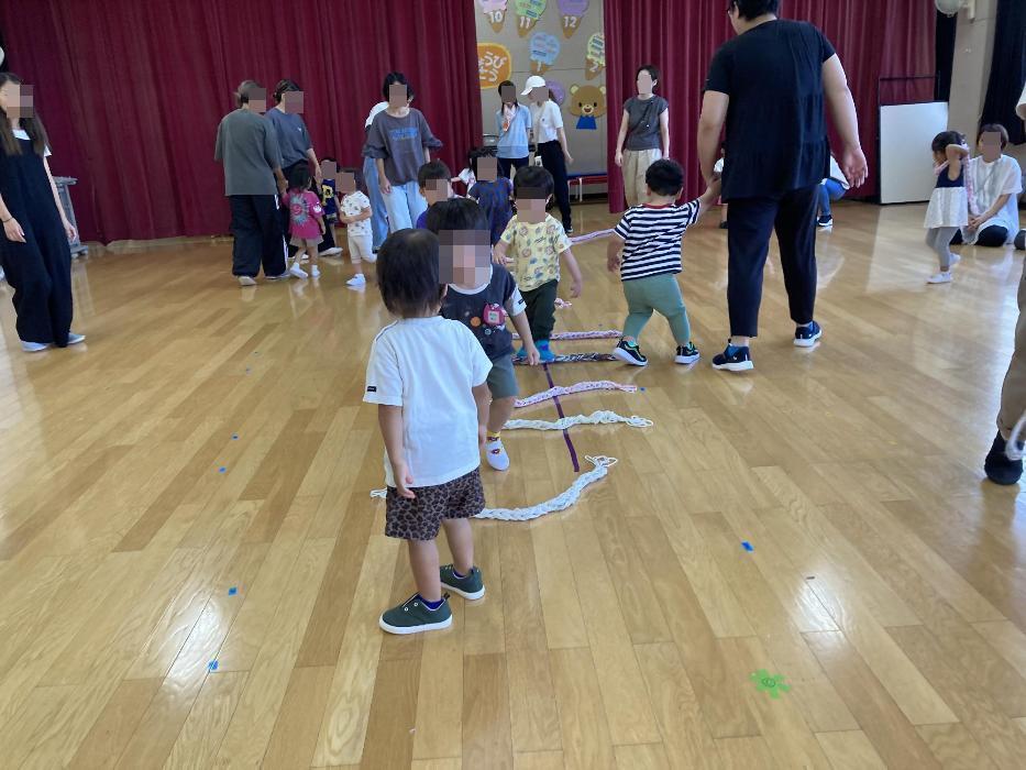 紐を使ってジャンプ遊びをする幼児の写真