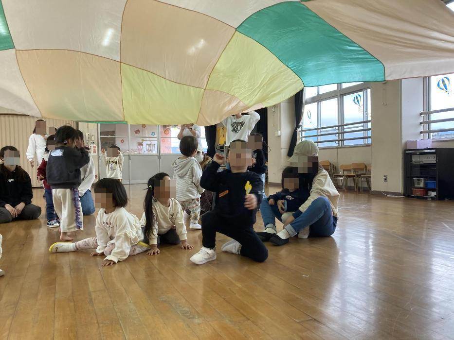 パラバルーンで遊ぶ幼児達の写真