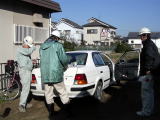 白い車を囲み施工体制点検中の男性3名の写真