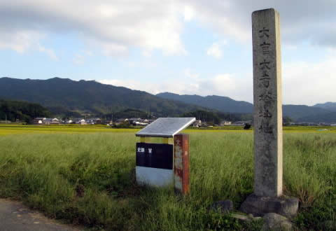 史跡として扱われている一面の草原に置かれている大官大寺跡の石碑とモニュメントの写真