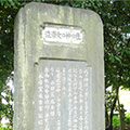 端が丸い長方形の石碑に、縦書きで文章が刻まれている石碑の写真