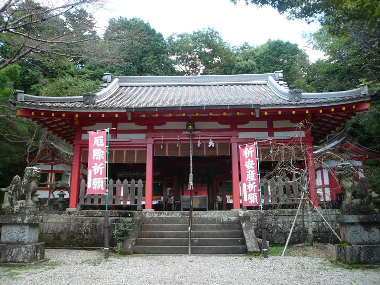左右に狛犬と、「厄除祈願」と書かれた赤い旗が2つ飾られた神社の写真