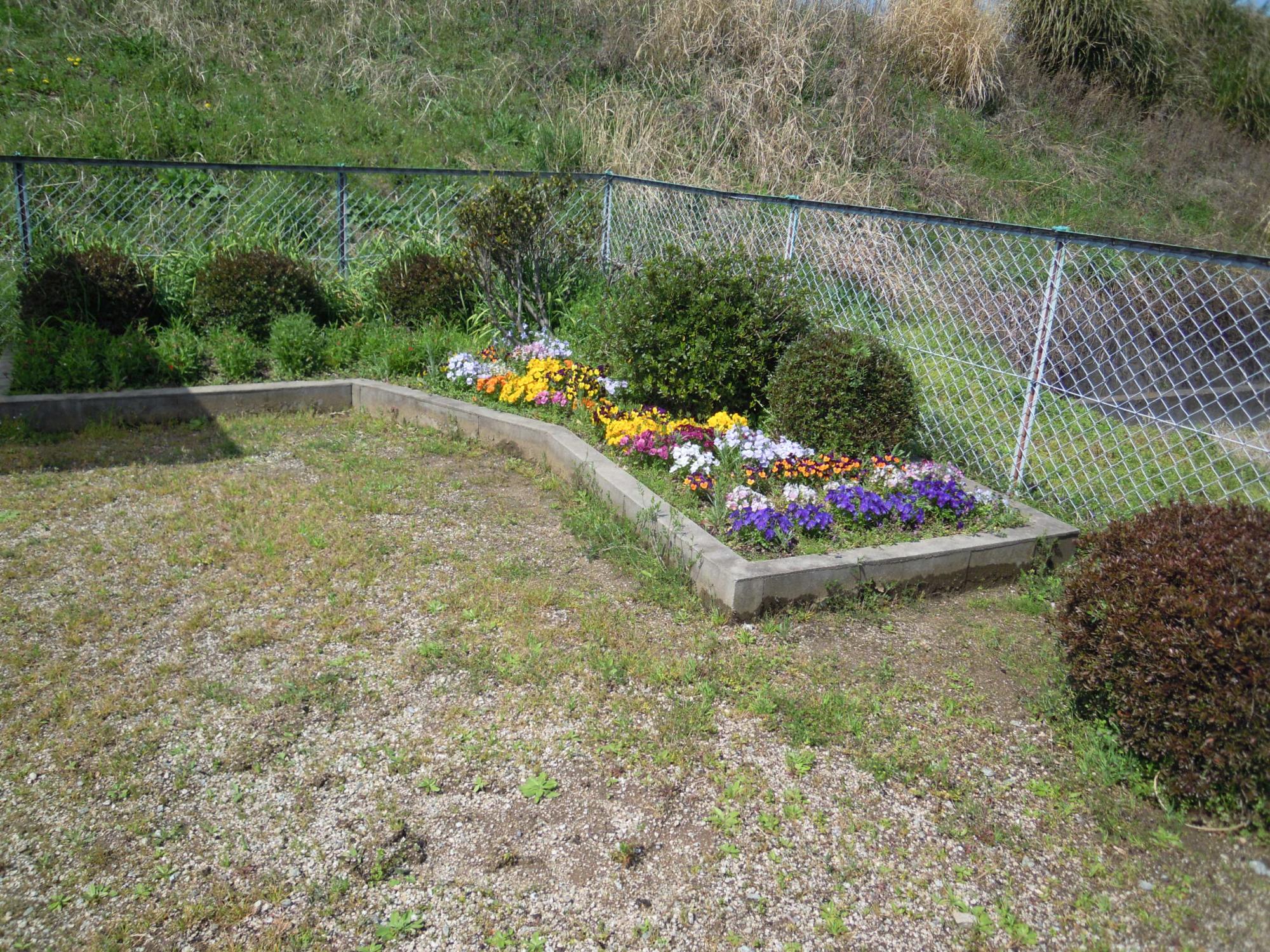 磐余団地児童公園 の北側にある色とりどりの花が咲いている花壇の写真